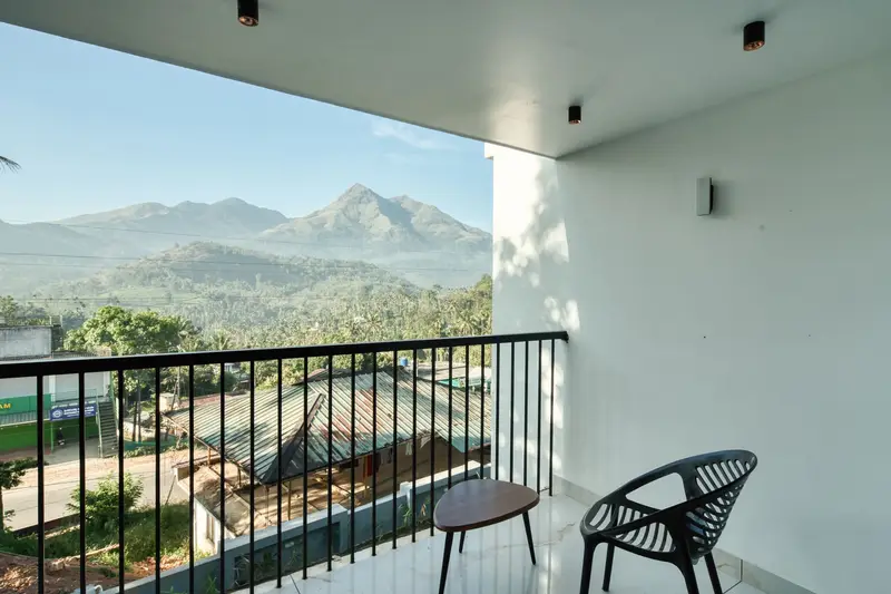 Two chairs on a bedroom balcony facing the mountains