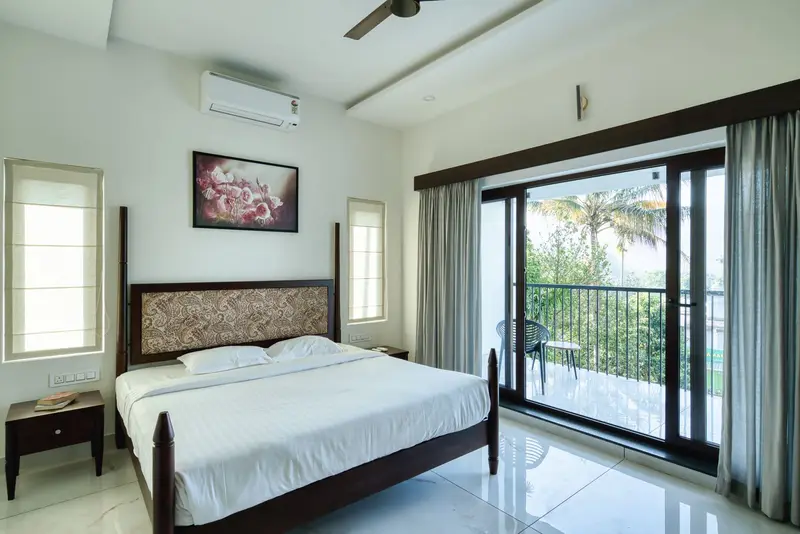Bedroom with a carved headboard and doors to a balcony