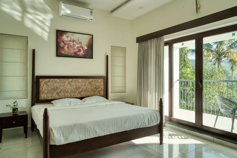 Bright bedroom with balcony doors looking onto palm trees