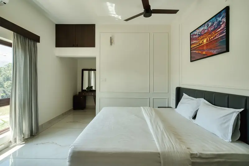 Bedroom with a grey headboard and a framed painting