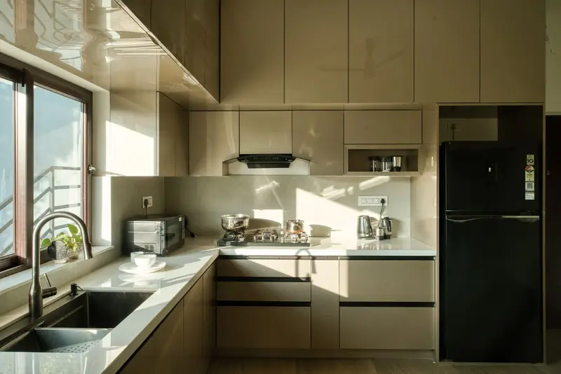 Kitchen with a fridge, hob, chimney and microwave