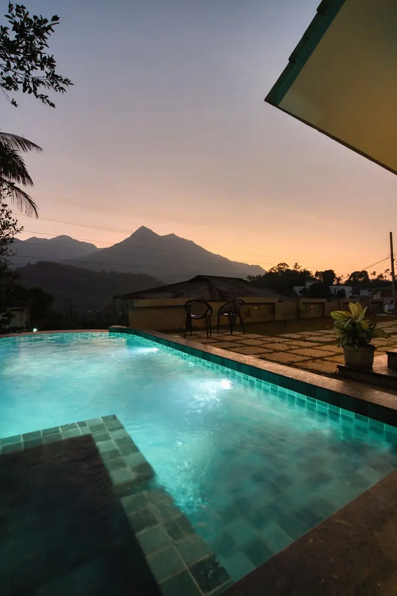 The pool at dusk under a pink sky over the hills