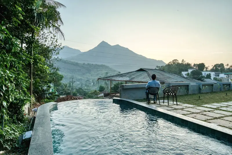 Infinity pool at Maison Claire facing the Wayanad hills in morning light